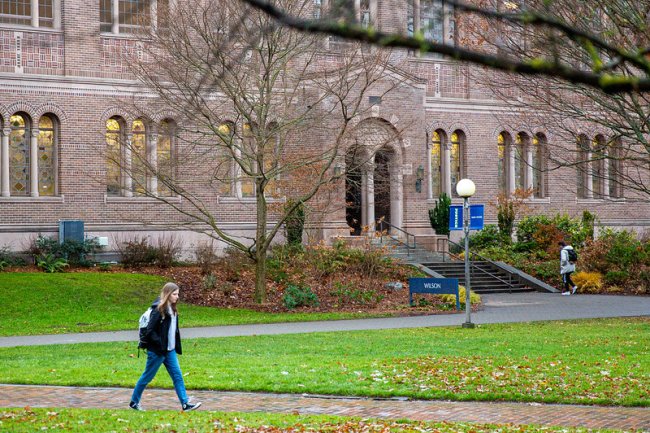 Student walking on a path in front of Wilson Library