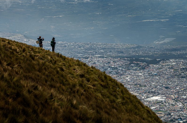 Two students look out over Quito, Ecuador, from a hillside.
