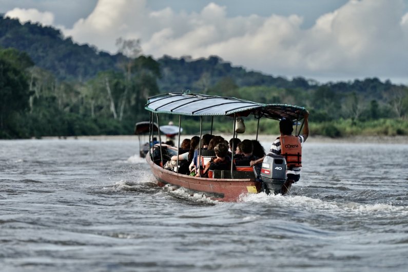Students ride in a motorized canoe across the Rio Napo, one of Ecuador's largest Amazon tributaries.