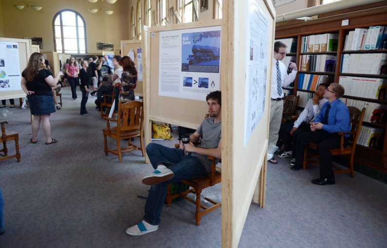 Western senior Carey Rose, a visual journalism major, center, sits by his typeface spec sheet project during a Scholars Week presentation Friday, May 20, in the Wilson Library Reading Room. Photo by Daniel Berman | University Communications intern