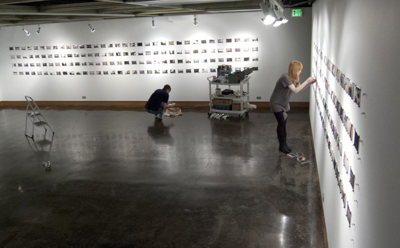AS Productions VU Gallery Coordinator Ashley Hollender and Western senior Casey Olive work on setting up the An Experiment exhibit in the VU Gallery before the exhibit opens Monday, January 9. For the exhibit, the anonymous creator gave out cameras to 17 