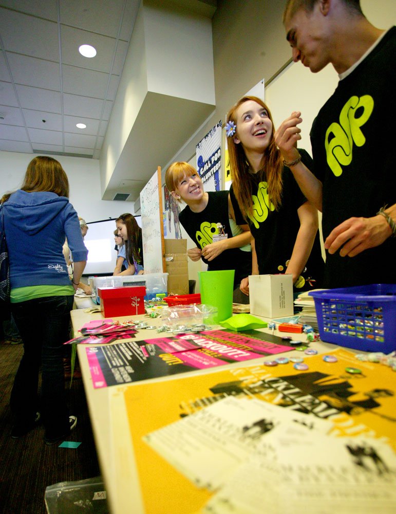 Western Washington University Associated Students employees Megan Housekeeper, Linnea Ingalls and Craig Gorder joke around while manning the AS Pop table at the Red Square Info Fair in the Viking Union Multipurpose Room on Monday, Sept. 20, 2010. The fair