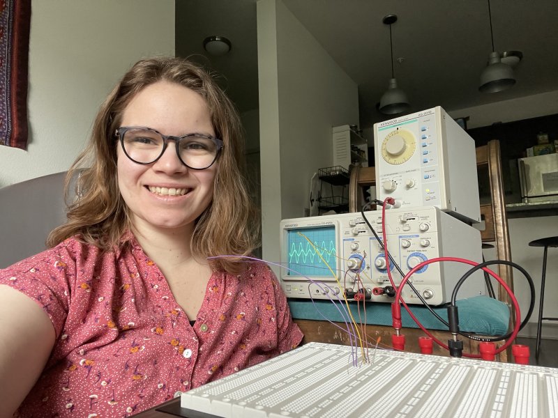 Andrea Wooley smiles for the camera, surrounded by scientific electronic equipment