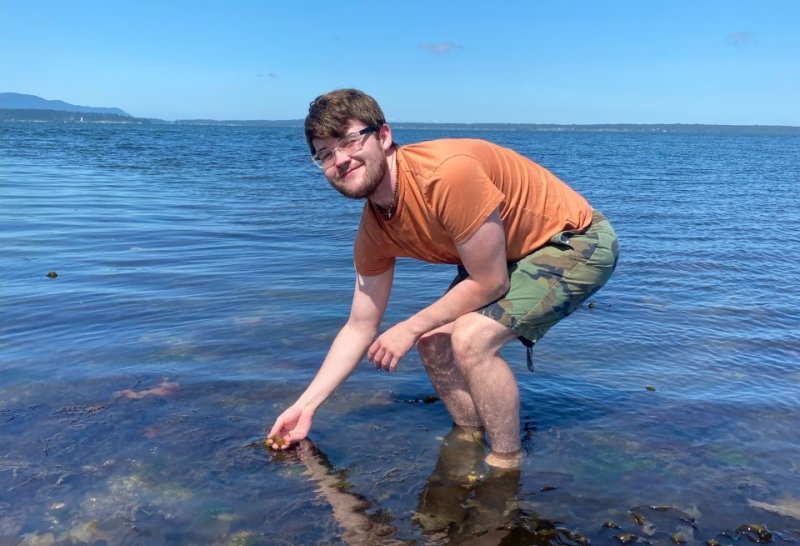 Jeremy Johnson observes algae at low tide for his research on benthic diatoms. 