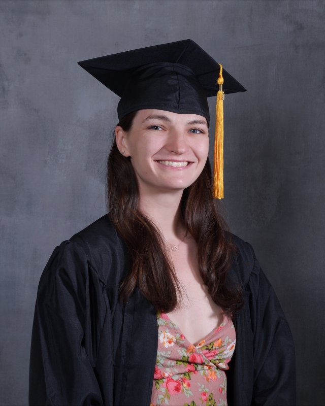 Natalie Culhane smiles for the camera wearing academic regalia