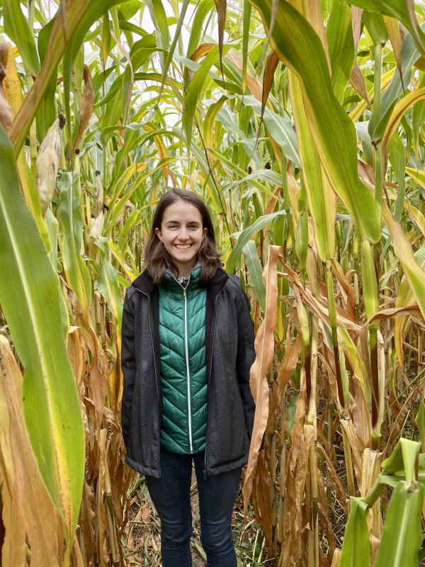 Rose Una smiles for the camera, surrounded tall stalks of corn