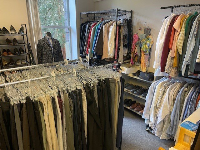  The image shows a room full of clothes on racks. There are clothes for both men and women, and there are different styles of clothes to choose from. There are also shoes and accessories available. The room is well-lit and organized, and it appears to be a thrift store or a clothing donation center.