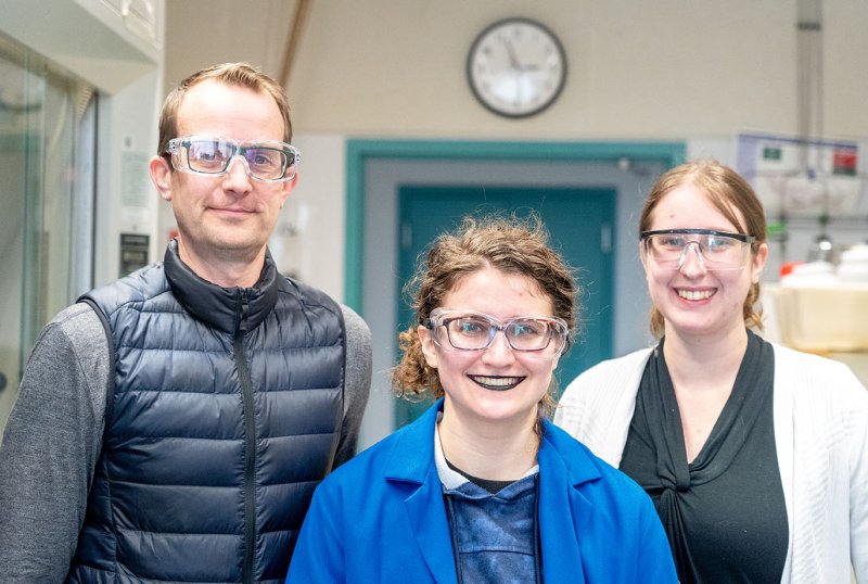 Chem students smile at the camera with their faculty advisor