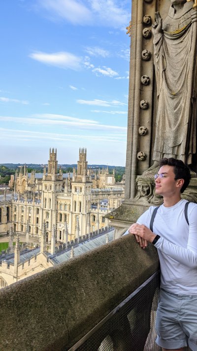 Nate Jo looks out on University of Oxford as he leans on a cement railing.