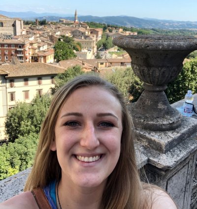 Julia Epps smiles with an ancient city sprawling in the background.