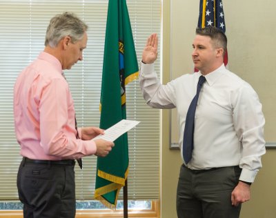 Rich Van Den Hul, vice president for WWU Business and Financial Affairs, swears in new University Police officer Monte Wallace. 