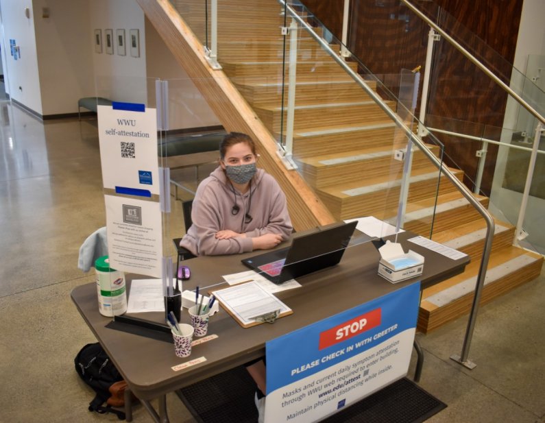 A student works at the check-in service at Viking Union that is now open for students. 
