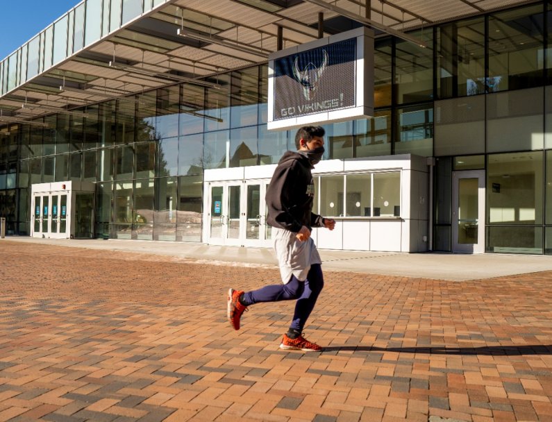 A jogger runs in front of Carver Gym.