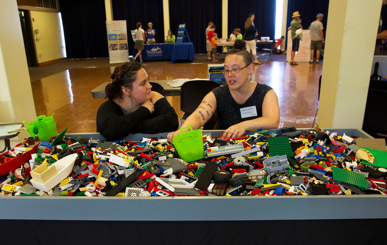 Inner Child Studio founder Rachel Andrews, right, shows off her collection of Lego blocks for people to play with at the Whatcom Robotics Expo Saturday, June 27, in the Viking Union Multipurpose Room. Photo by Mariko Osterberg / WWU Communications and Mar