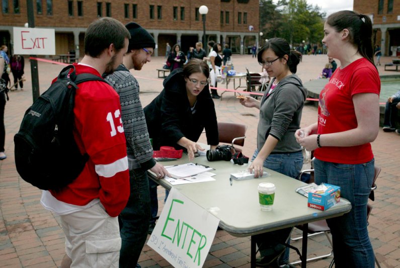 WWU students Becky Tachihara (grey sweatshirt) and Liza Weeks (far right) welcome students to the fictional nation Democratic People's Republic of Liberty on May 12, 2011. Photo by Shea Taisey | University Communications intern
