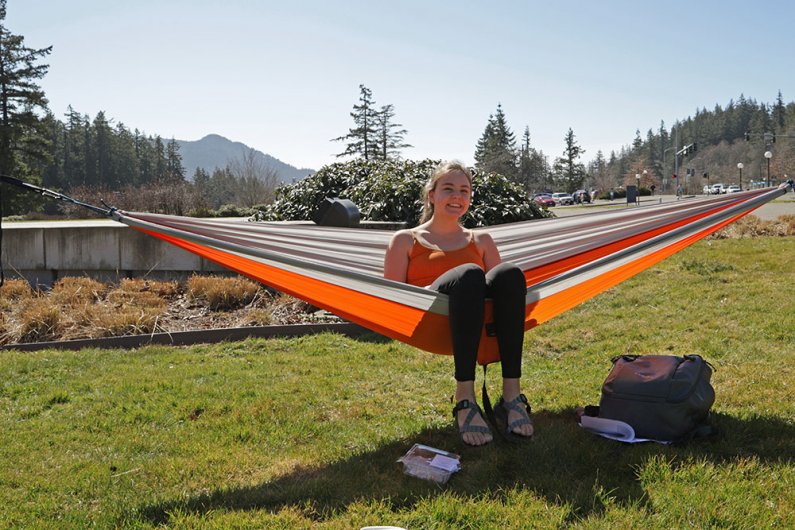 Sophomore Nora Harren hangs a hammock on south campus to enjoy the sunny day with some friends on Tuesday, March 19.